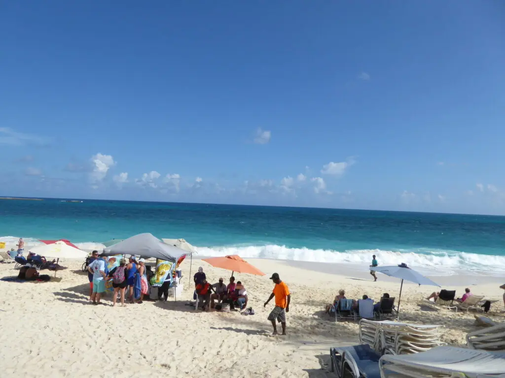 Strand mit türkisem Meer und Sonnenliegen in Nassau auf den Bahamas