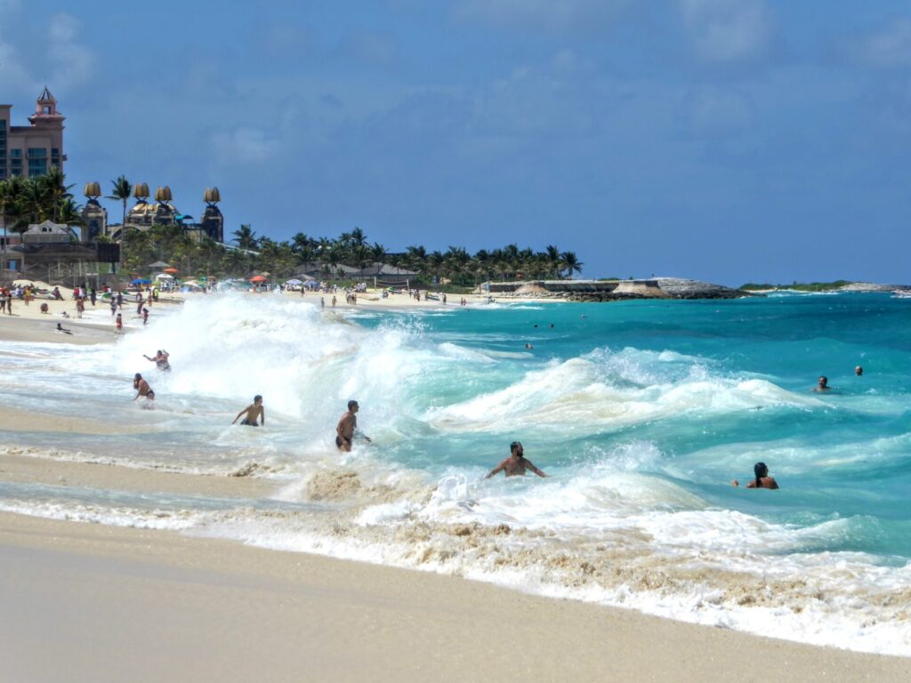 Hohe Wellen und Menschen am Strand in Nassau auf den Bahamas