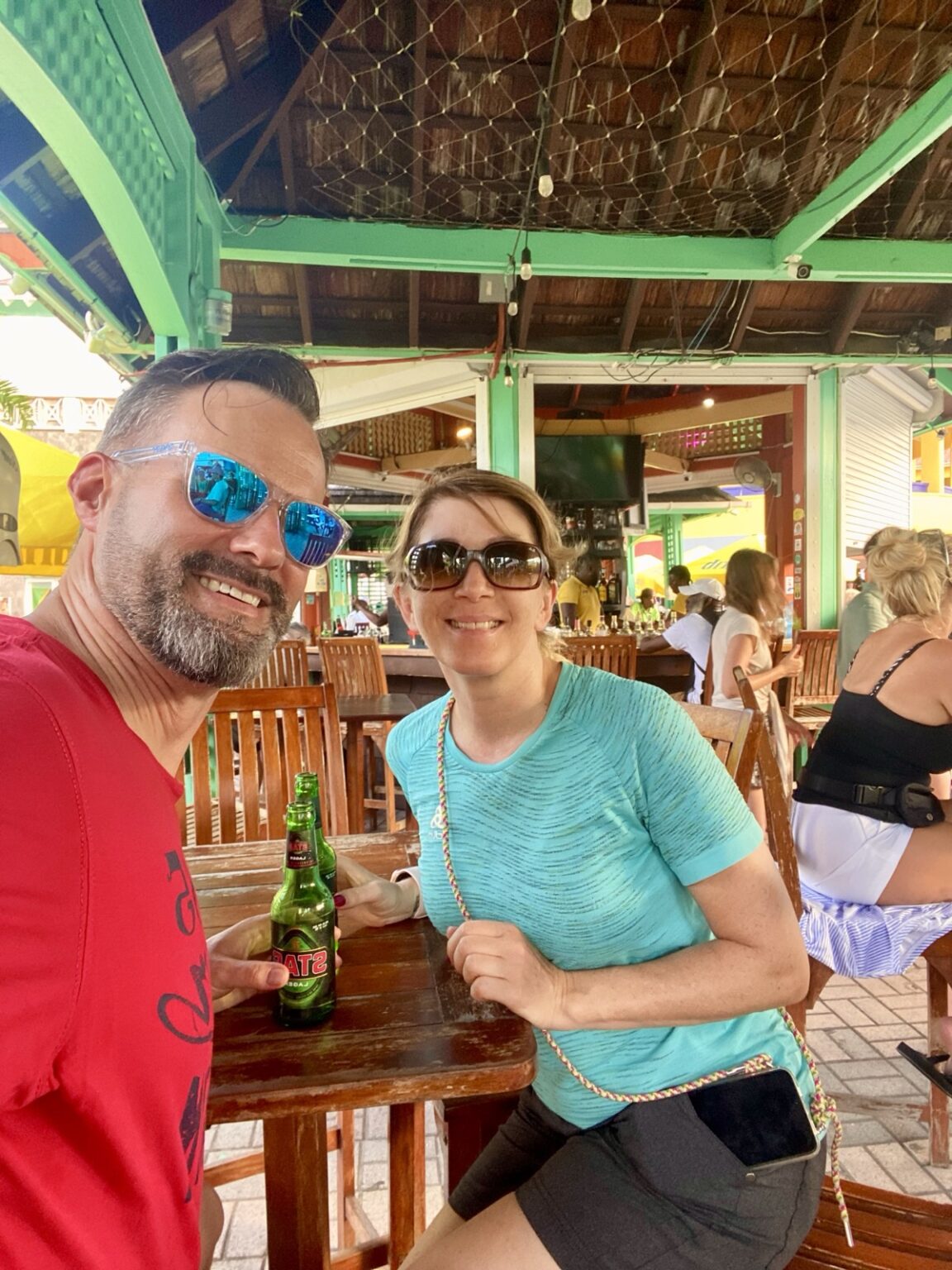 Paar in St. Kitts Bar mit Carib-Bier