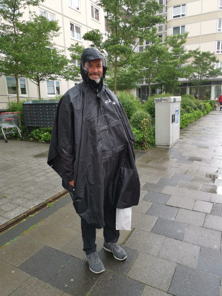 Mann im schwarzen Regenponcho