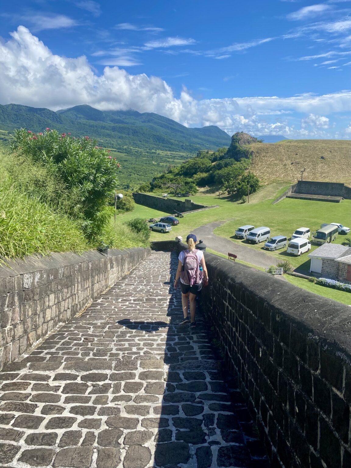 Touristen auf Brimstone Hill Festungsmauern St. Kitts mit Kopfsteinpflaster und Bergblick
