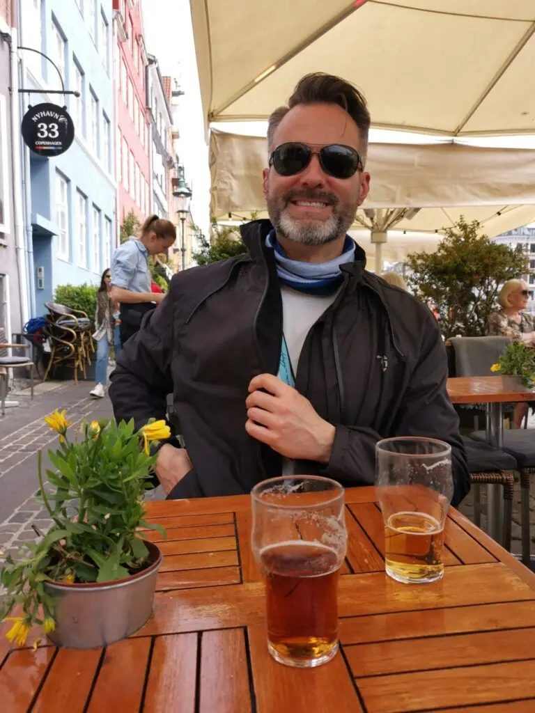 Mann mit Bier am Holz-Tisch in Kopenhagen