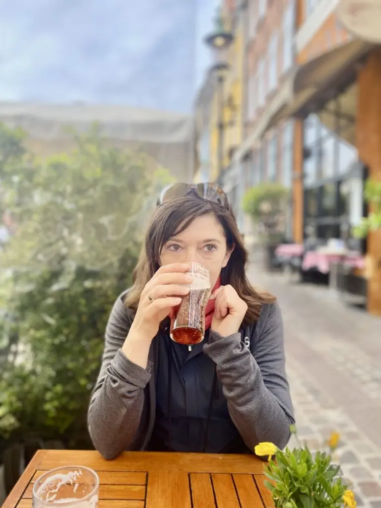 Frau trinkt Bier am Tisch 