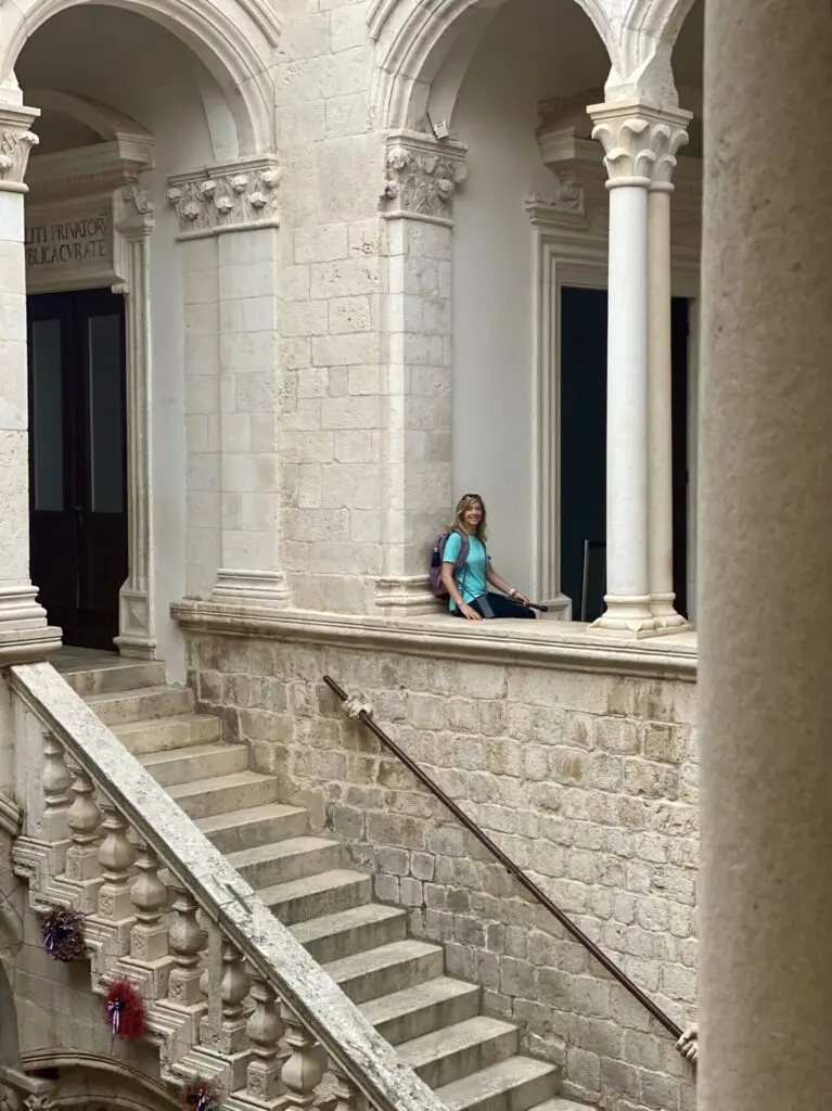 Treppe und Säulengang mit Frau im Rektorenpalast in Dubrovnik