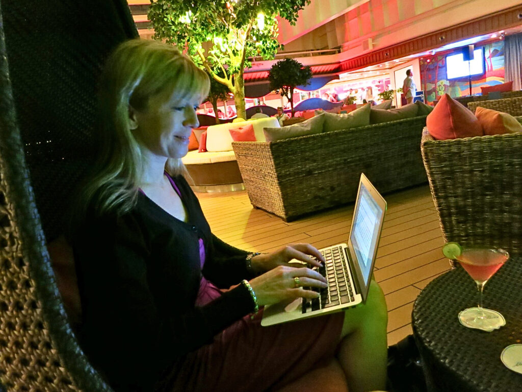 Frau mit Laptop auf Kreuzfahrtschiff