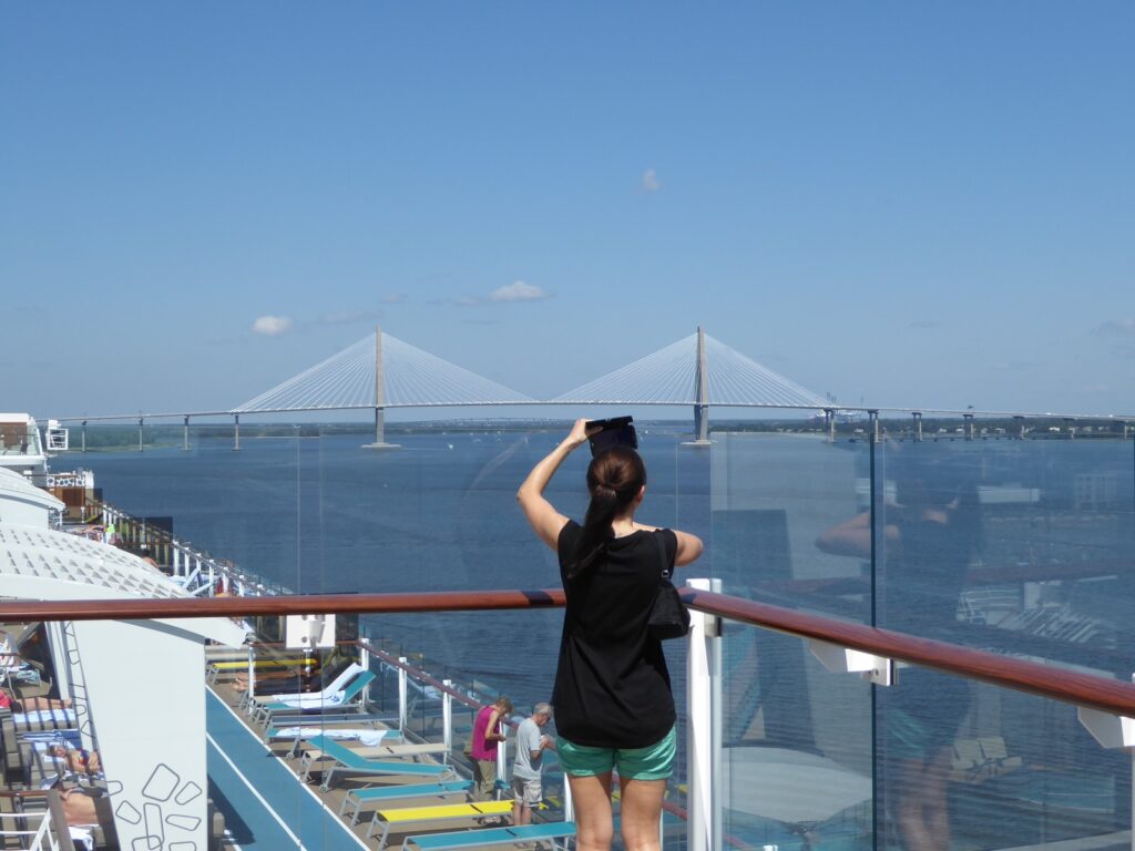 Frau mit Handy auf Kreuzfahrtschiff