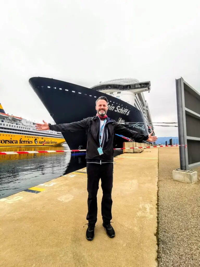Mein Schiff am Hafen mit Mann mit ausgestreckten Armen in Ajaccio
