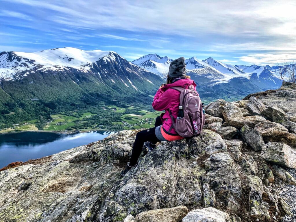 Frau auf dem Nesaksla mit schneebedeckter Bergwelt
