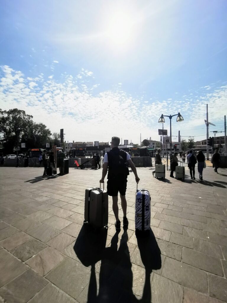 Mann mit Koffer am Bahnhof Venedig