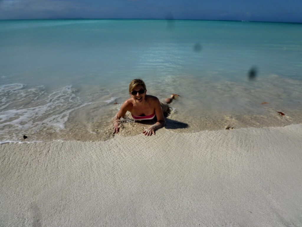 Frau am Strand mit türkisem Meer auf Antigua St. Johns