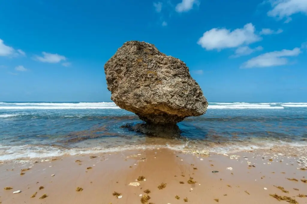 Großer Stein mit türkisem Meer am Strand auf Barbados 