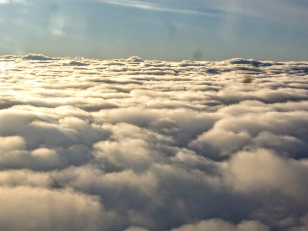 Blick aus dem Flugzeug auf Wolkendecke