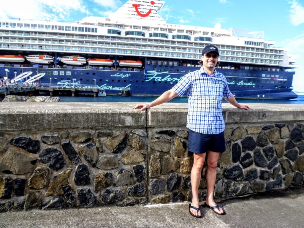 Mann am Hafen von Roseau mit Mein Schiff