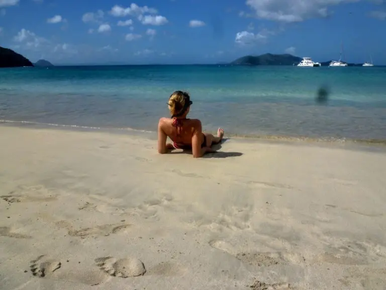 Frau liegt im Sand in Road Town Tortola