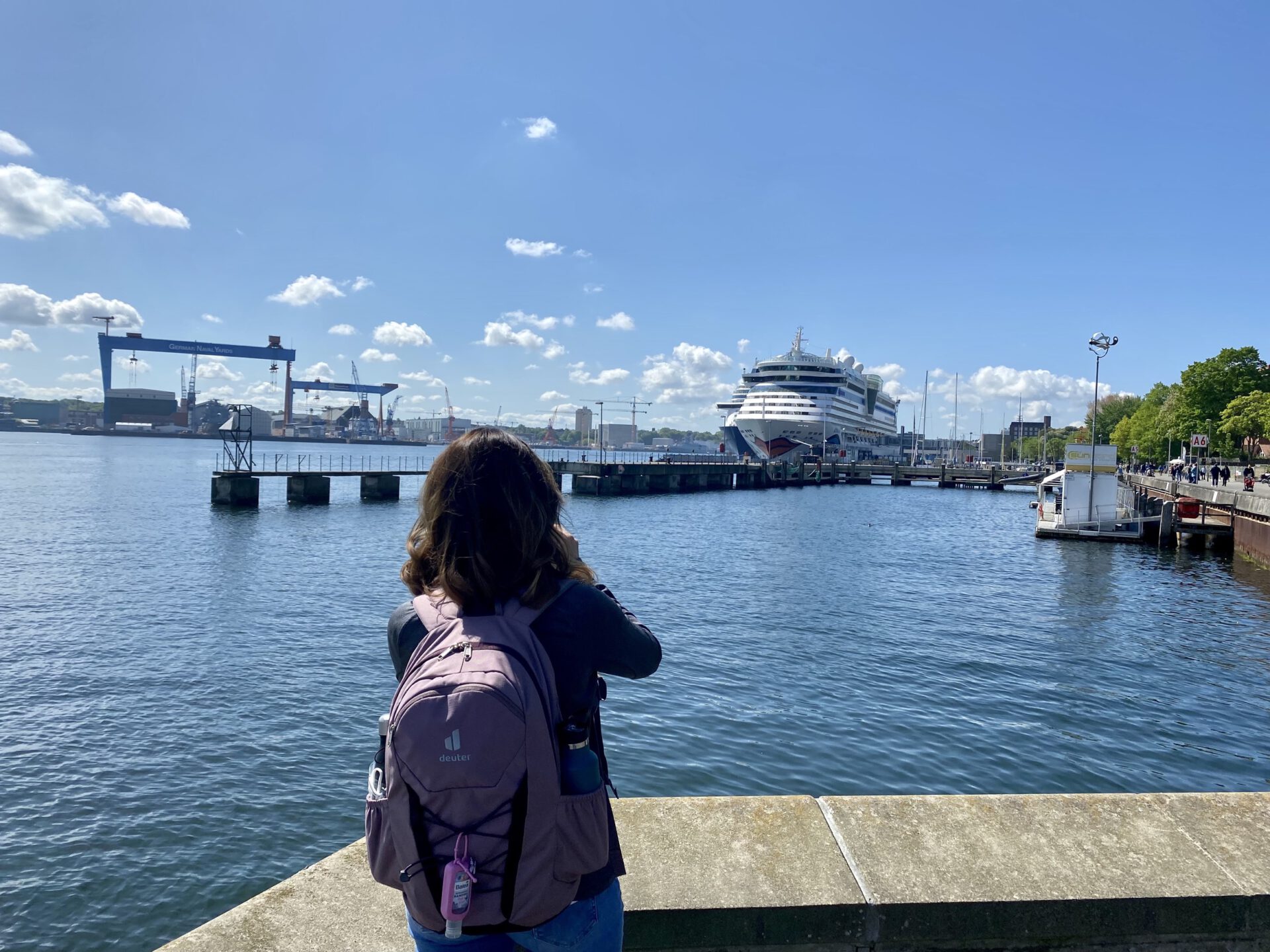 Frau und Kreuzfahrtschiff am Hafen Kiel