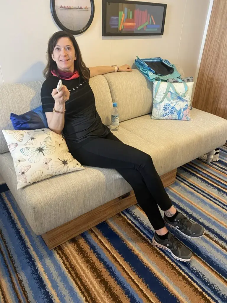 Sofa mit Frau in einer Balkonkabine Kreuzfahrtschiff