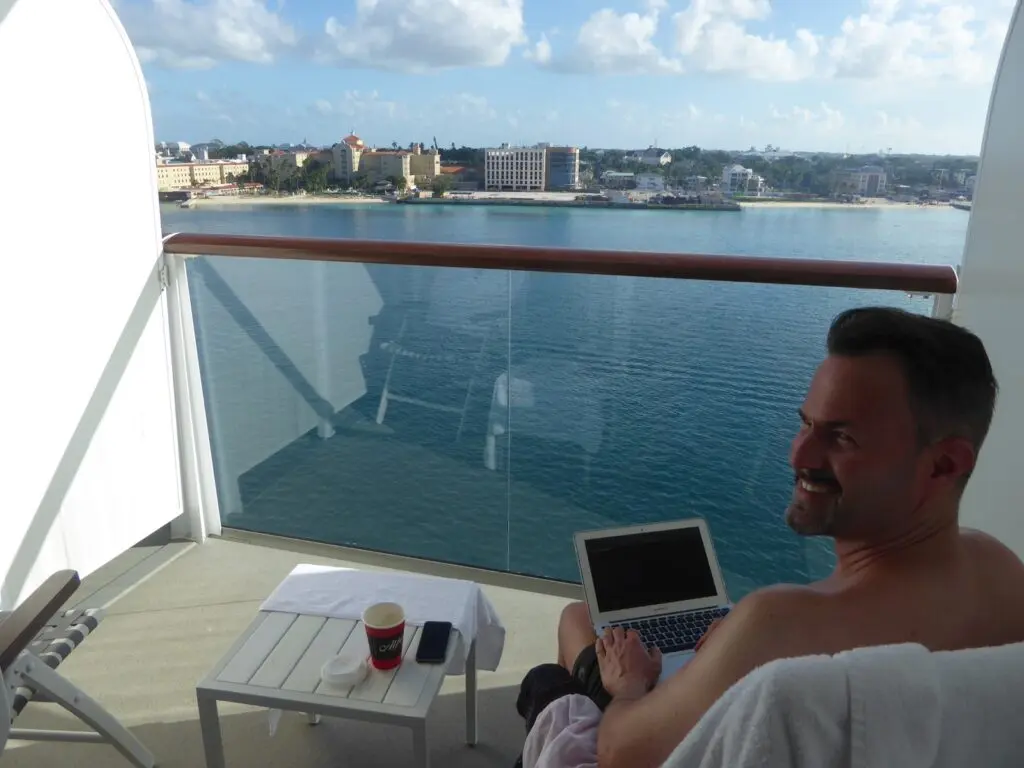 Mann mit Computer auf Balkonkabine Schiff