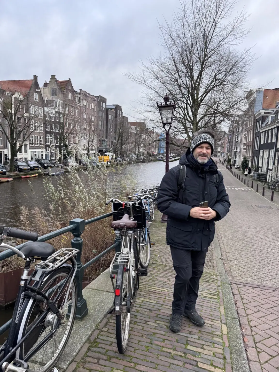 Mann mit Rad und Gracht in Amsterdam