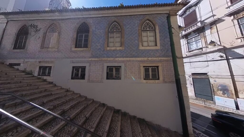Steile Gasse mit buntem Haus in Lissabon