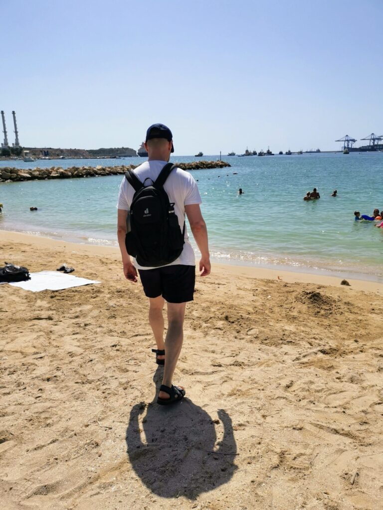 Mann geht am Strand  von Marsaxlok