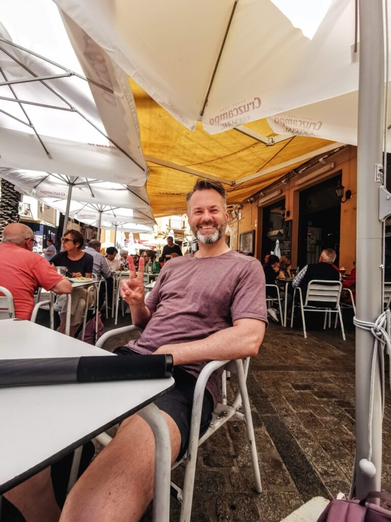 Mann im Café unter Sonnenschirm in Cadiz
