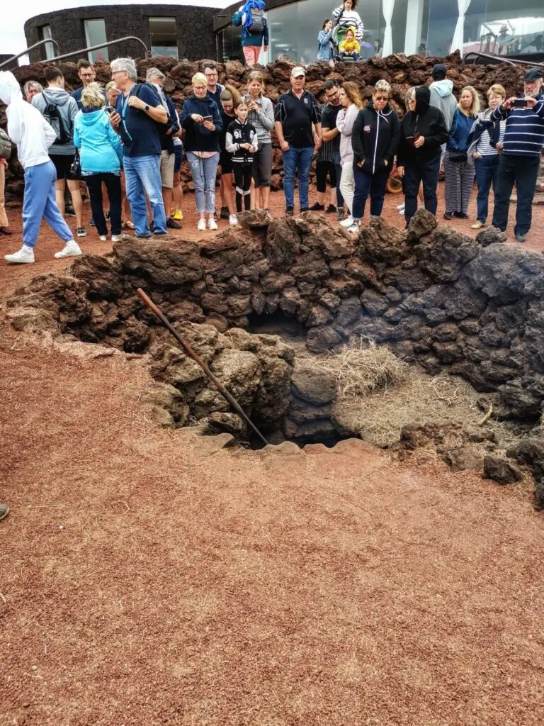 Menschen Gruppe steht um Erdloch im Naturpark Timanfaya in Lanzarote