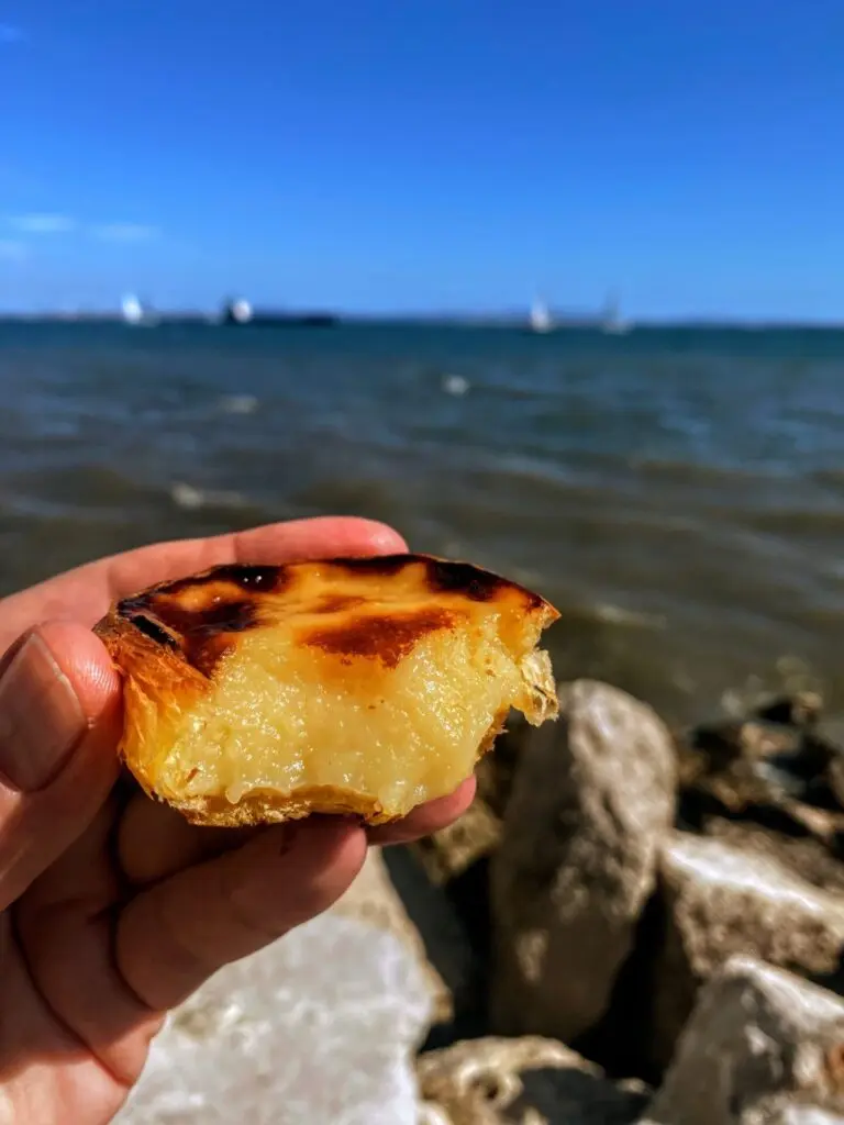 Pastéis de Belém in einer Hand mit Abbiss in Lissabon
