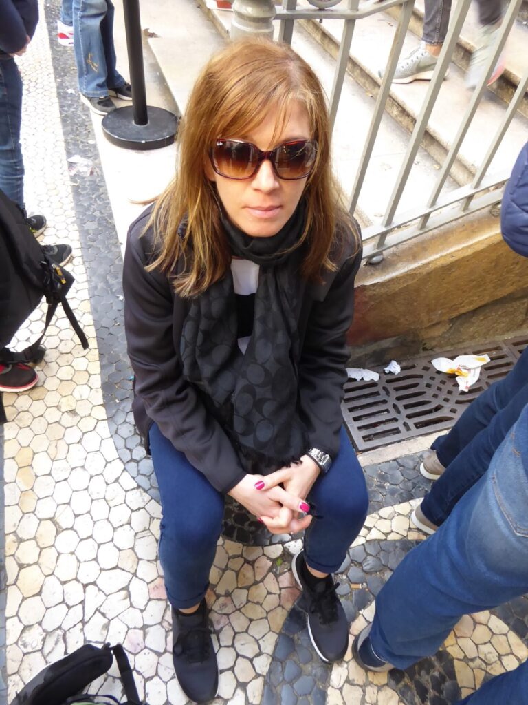 Frau wartet vor Elevador de Santa Justa in Lissabon