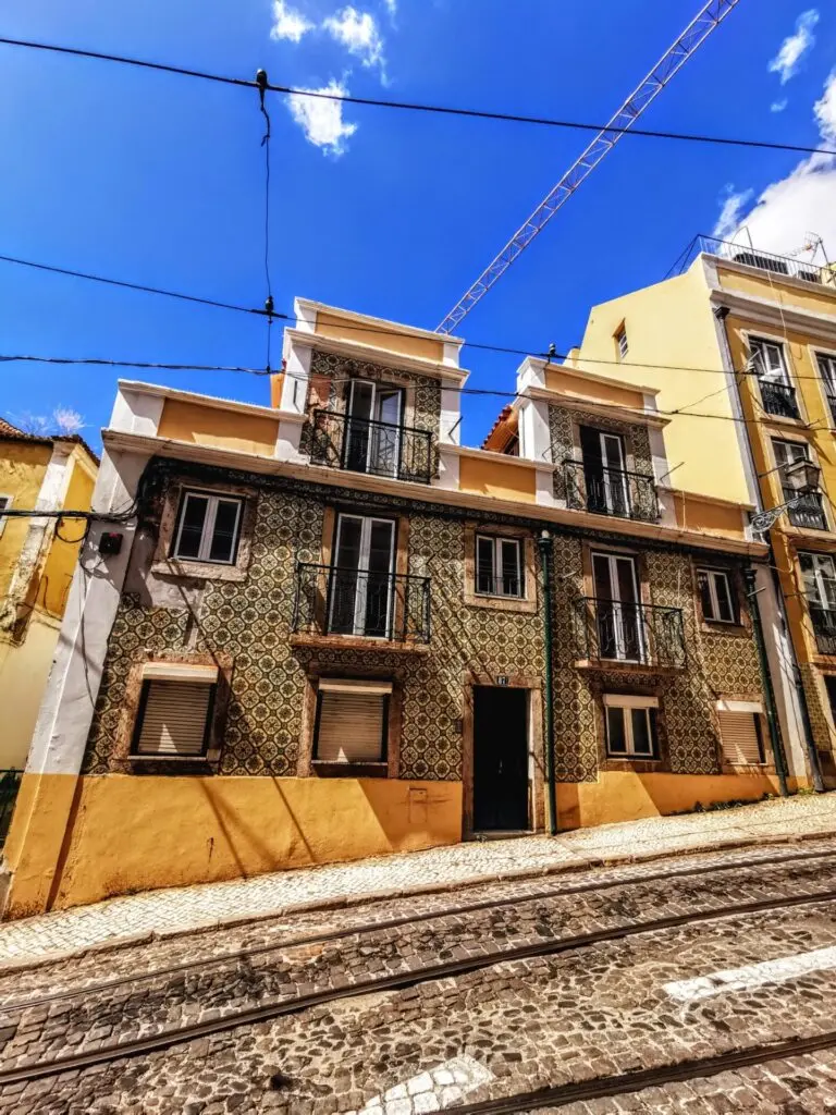Tramschienen in einer bunten Gasse in Lissabon