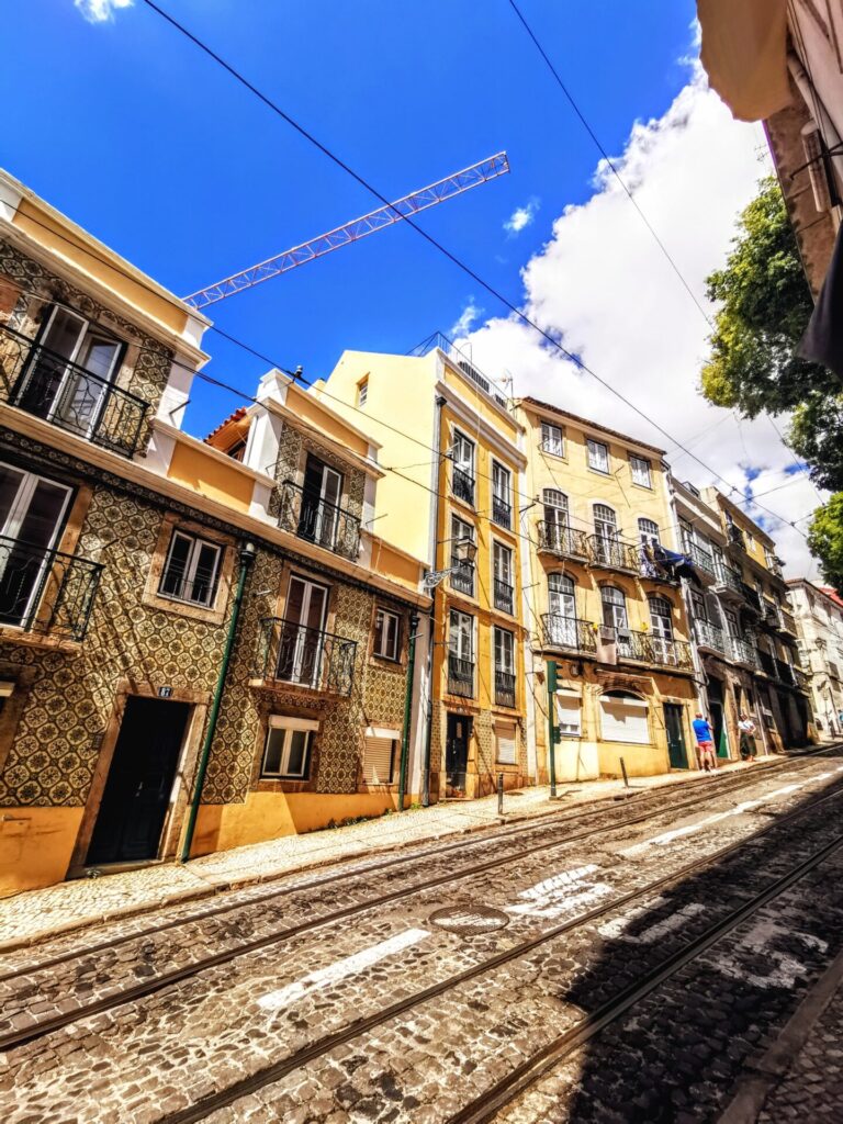 Tramschienen in einer bunten Gasse in Lissabon