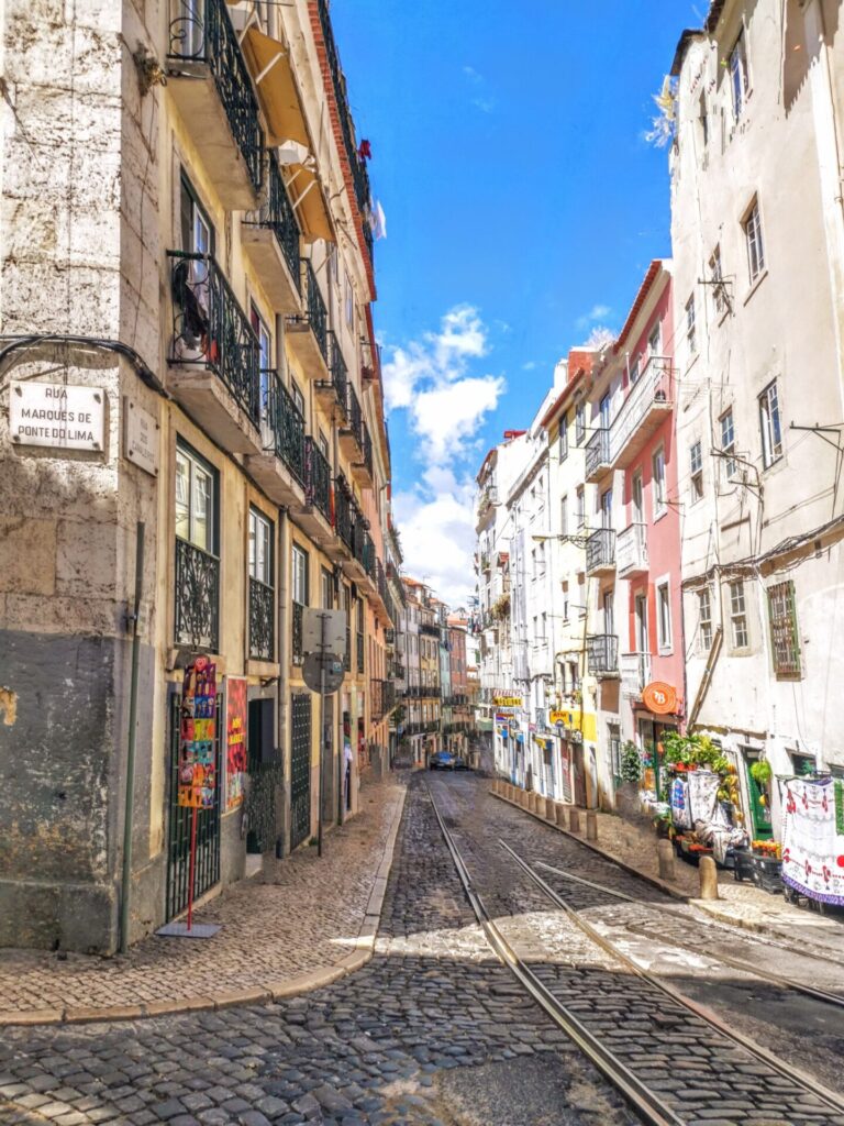 Tramschienen in einer bunten Gasse in Lissabon
