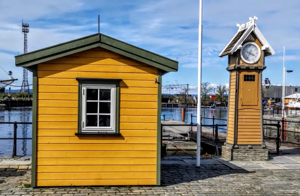 Pier mit gelben Holzhaus und Uhr in Trondheim