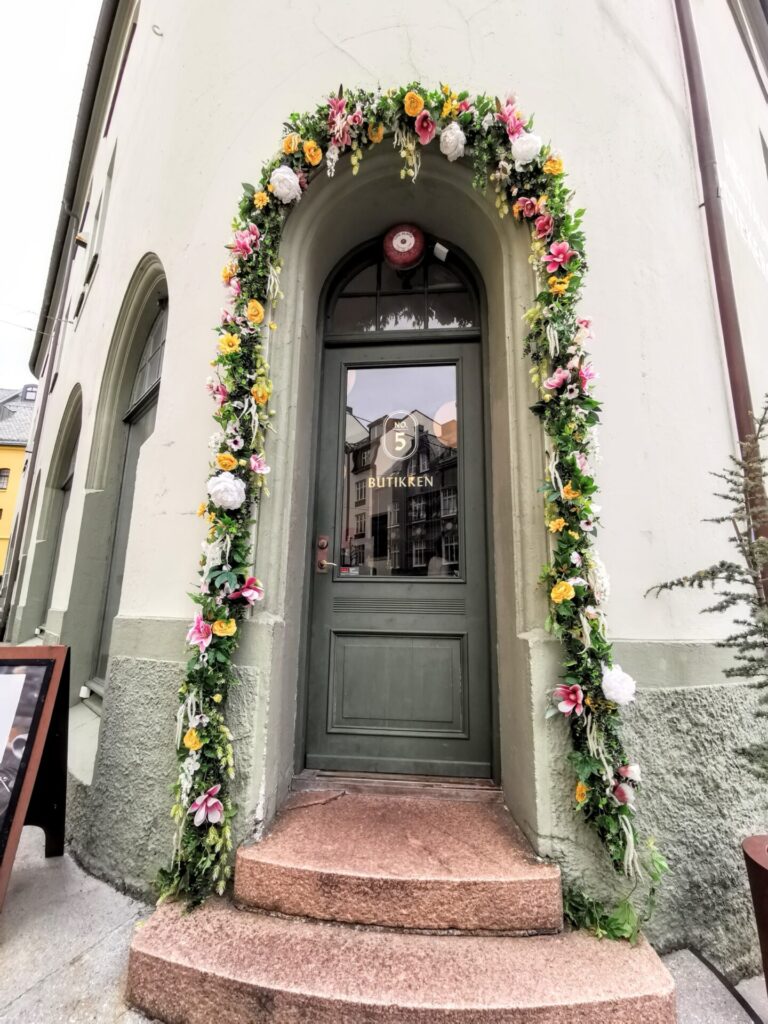 Grüner Eingang mit Blumenkranz im Zentrum von Alesund
