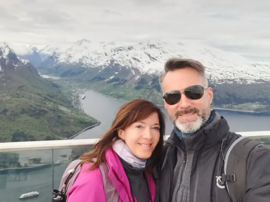 Ausblick vom Hoven auf Olden und die schneebedeckte Berglandschaft mit Fjord mit Pärchen