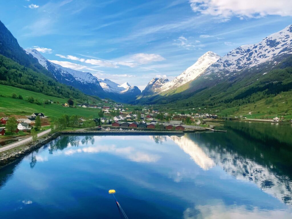 Blick aus den Hafen von Olden mit Fjord und schneebedeckter Berglandschaft
