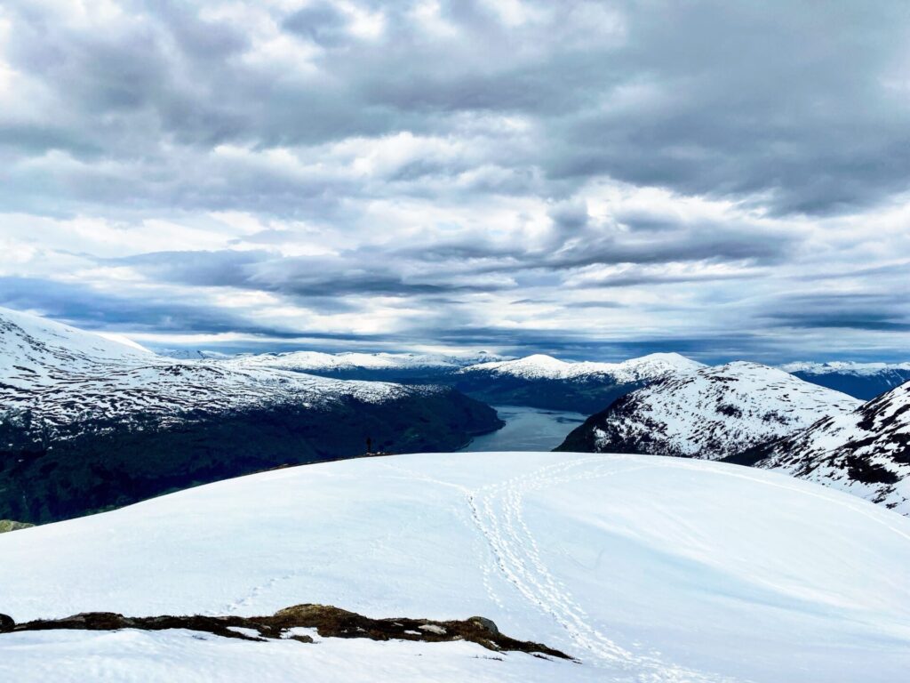 Ausblick vom Hoven auf Olden und die schneebedeckte Berglandschaft mit Fjord