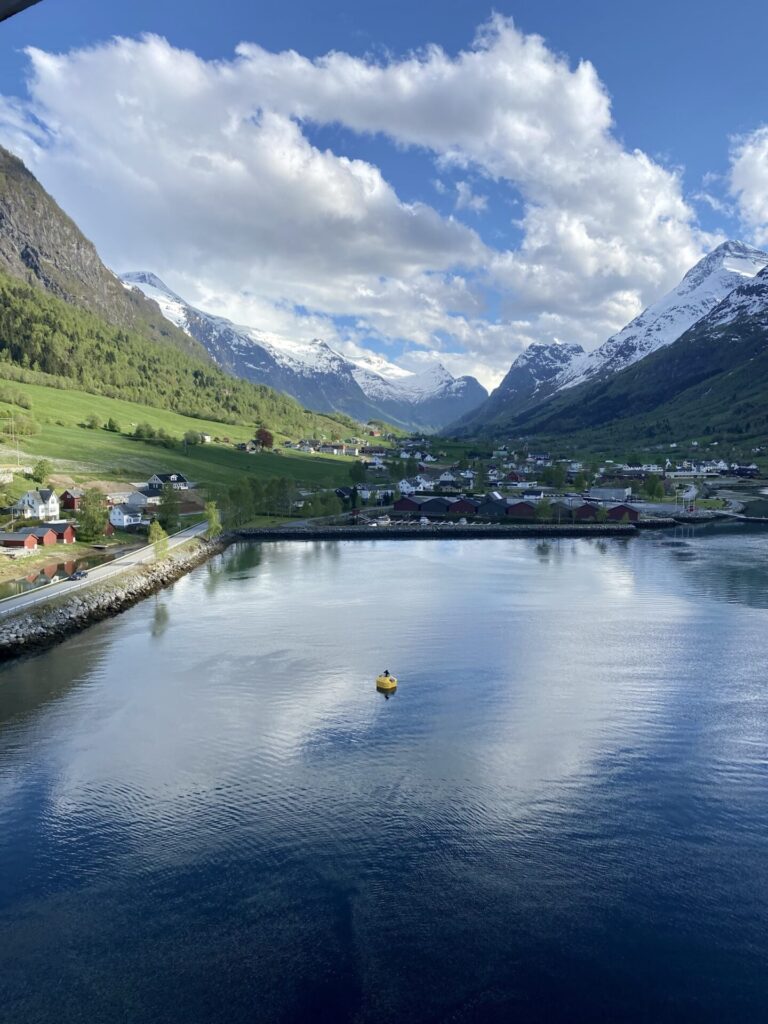 Blick aus den Hafen von Olden mit Fjord und schneebedeckter Berglandschaft