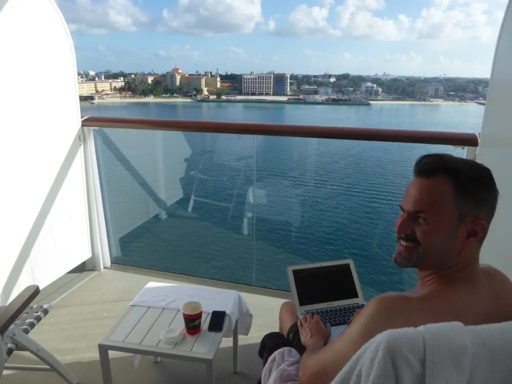 Mann sitzt auf Balkonkabine auf einem Kreuzfahrtschiff
