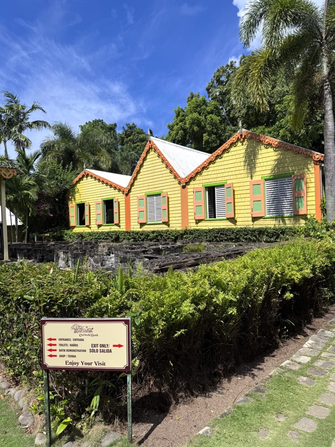 Historisches gelbes Kolonialhaus St. Kitts mit roter Verzierung und Informationstafel,